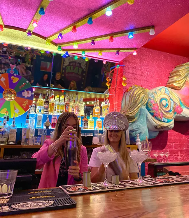 Cuckoo Hen & Stag Parties. Two women making cocktails during a masterclass in Cuckoo Fairground on Call Lane.